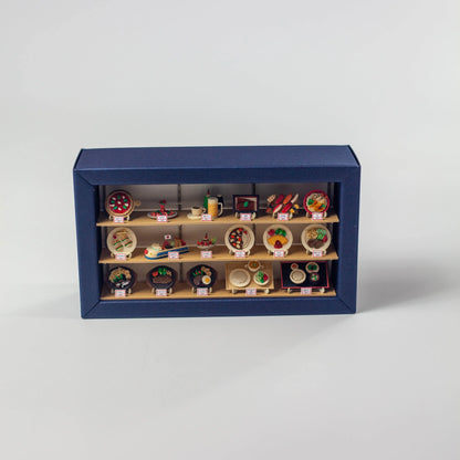 ジャパミニ ショーウインドーの完成品。青い枠の3段棚に料理のミニチュアが並ぶペーパークラフト