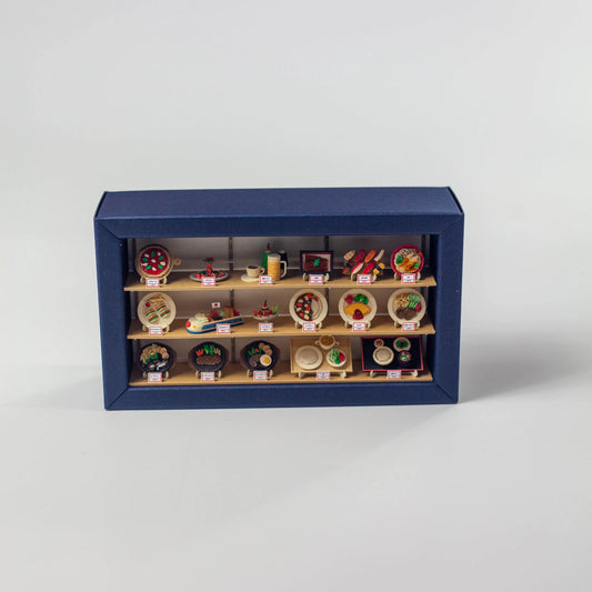 ジャパミニ ショーウインドーの完成品。青い枠の3段棚に料理のミニチュアが並ぶペーパークラフト
